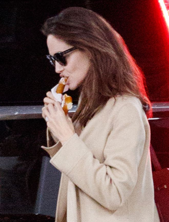 Джоли кушает пончик