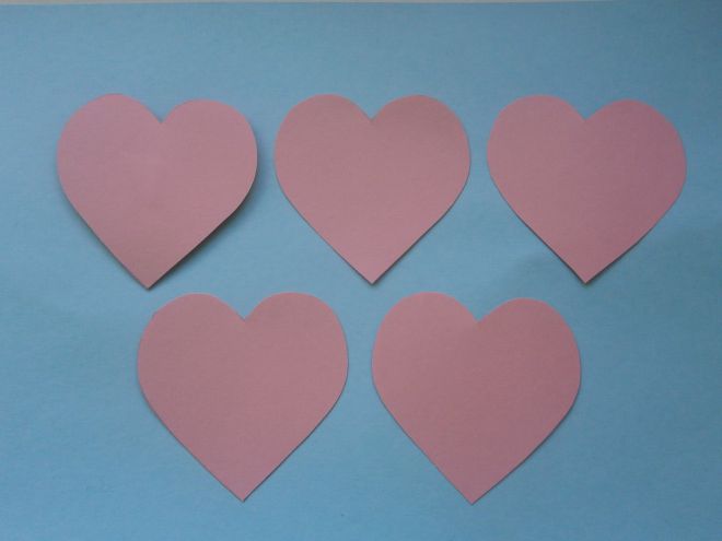 Изрежете големи сърца от розова хартия