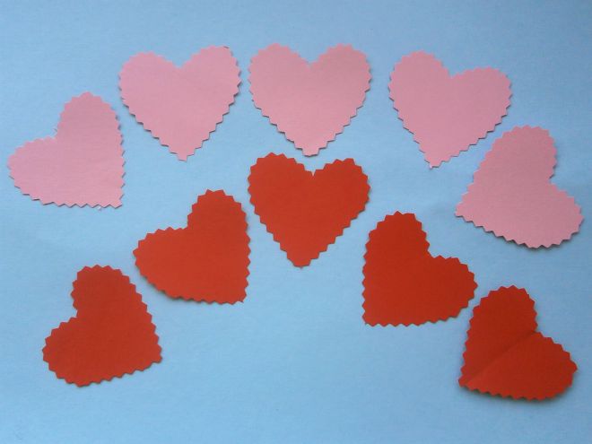 Изрежете малки сърца от червена и розова хартия
