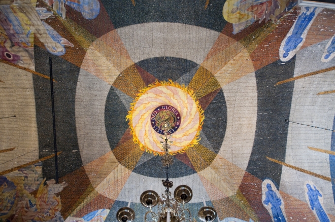 В центре потолка сияет огромное солнце с надписью Gloria in excelsis Deo