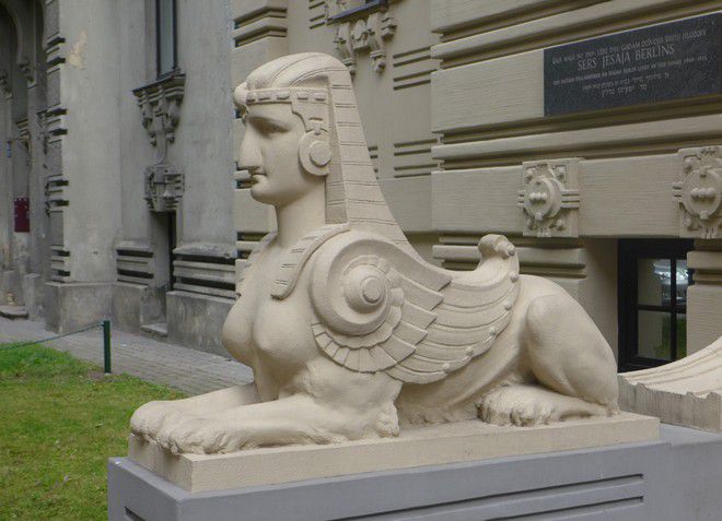 Скульптура сфинкса возле входа в здание