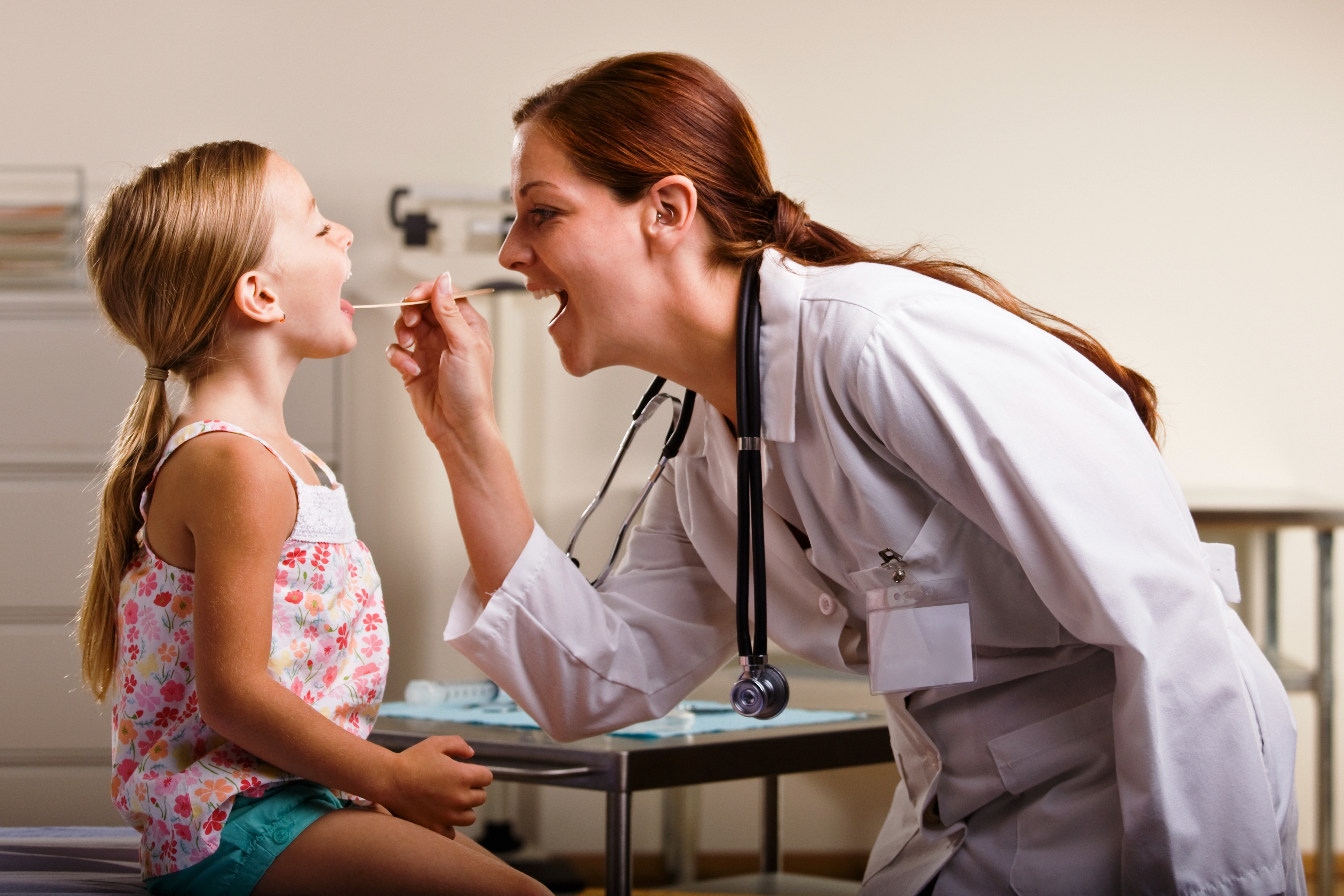 Осмотр зева ребенка. Ребенок на приеме у врача. Врач осматривает ребенка. Врач осматривает горло.