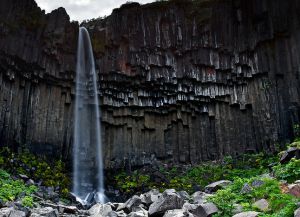 Водопад Свартифоосс на фоне черных базальтовых колонн